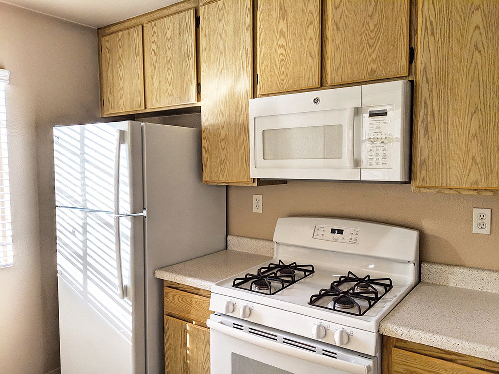 A fridge and stove in an affordable kitchen at the Westbrook Apartments in San Diego, California.